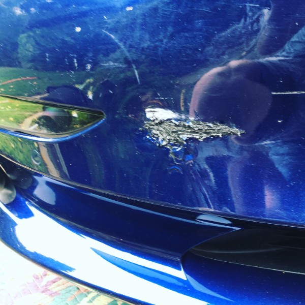 Deep scratch on blue Tesla bumper prior to mobile tesla paint repair in Phoenix Arizona